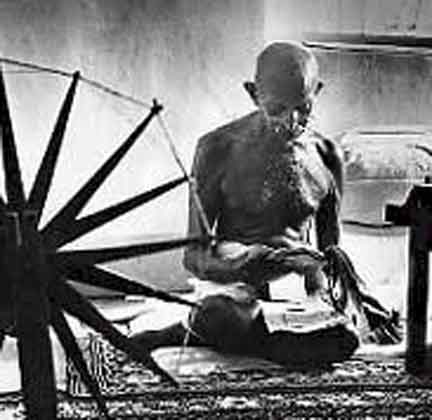 A telecom mobile tower stands next to a Mahatma Gandhi statue